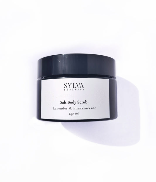 Black jar with white label containing Sylva Botanics lavender and frankincense salt body scrub on white background.